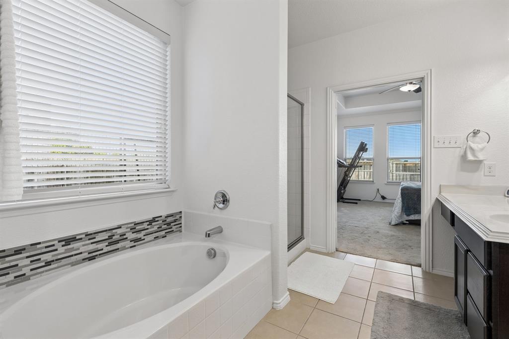 Soaking tub with a mosaic tile surround and chrome fixtures