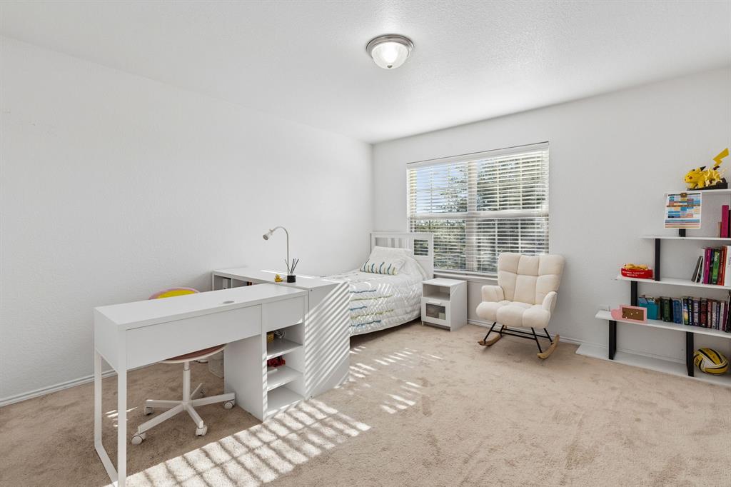 Carpeted room with a ceiling-mounted light fixture and a window with blinds