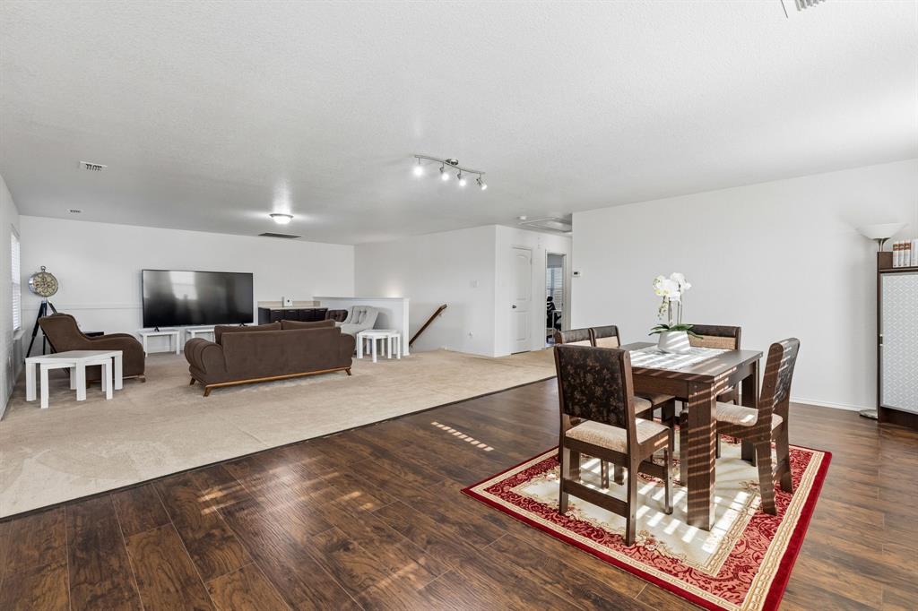 Expansive open-concept living area featuring wood-finish flooring, recessed lighting, and a neutral color palette
