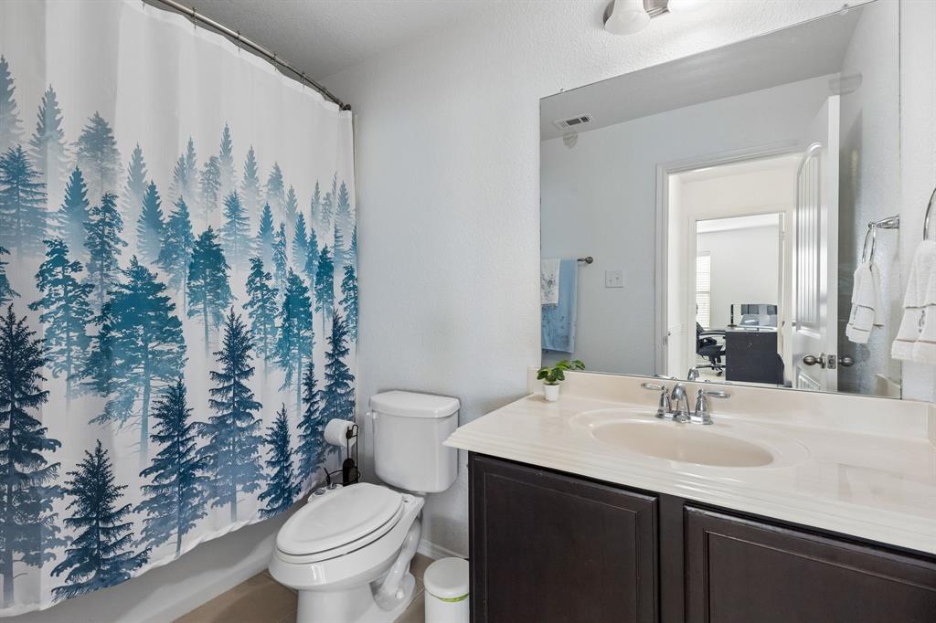 Bathroom featuring a vanity with an integrated sink, polished chrome faucet, dark wood-finish cabinetry, and an expansive wall mirror