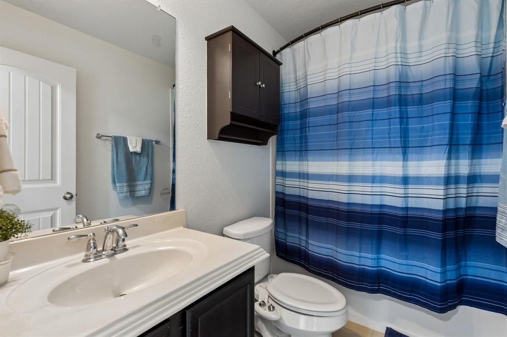 Bathroom featuring a vanity with an integrated sink, polished chrome faucet, full-width mirror, and built-in wall cabinet