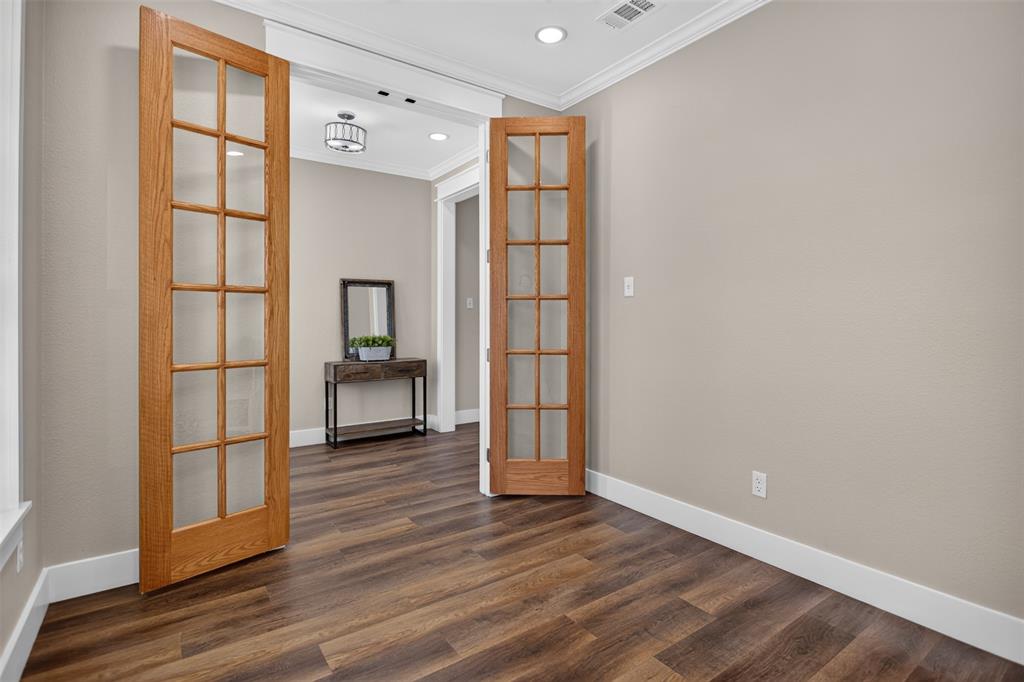 Wood-finish flooring, double glass-paneled interior doors with wood trim, recessed lighting, and crown molding in the office or potential fourth bedroom.