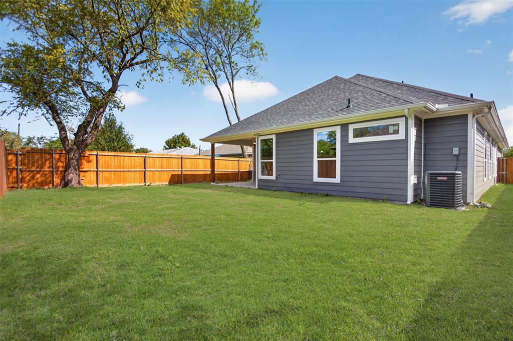 Backyard featuring a grass lawn, horizontal siding exterior, covered patio, and wood privacy fencing