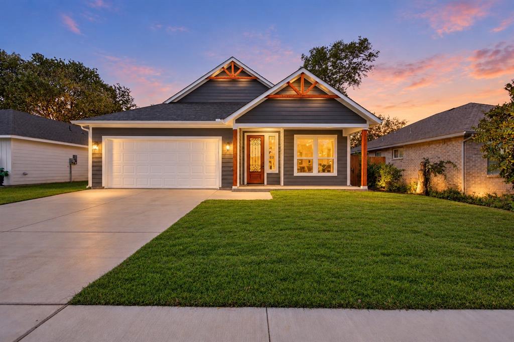 Exterior elevation featuring horizontal lap siding, a dual-gabled roofline with exposed wood trusses, a covered entry with wood-finish columns, and an attached two-car garage Exterior elevation featuring horizontal lap siding, a dual-gabled roofline with exposed wood trusses, a covered entry with wood-finish columns, and an attached two-car garage