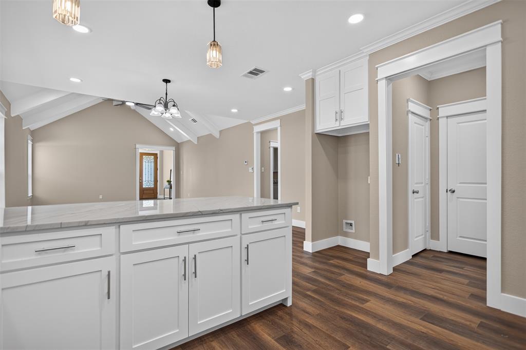 Kitchen island with granite finish countertop, white Shaker-style cabinetry, vaulted ceiling with exposed beams, wood-finish flooring, and recessed lighting