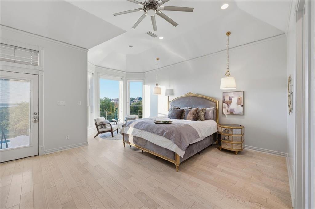 Tray ceiling featuring recessed lighting and a ceiling fan, light-toned wood-finish flooring, bay window architecture, and dual pendant light fixtures