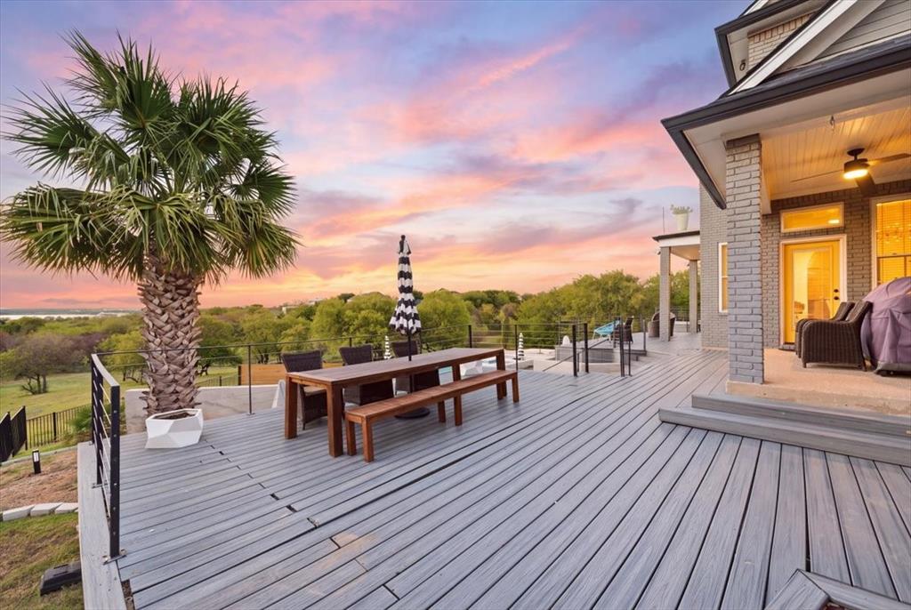 Multi-level composite deck featuring metal railing, integrated structural columns, covered porch area, and professional landscaping