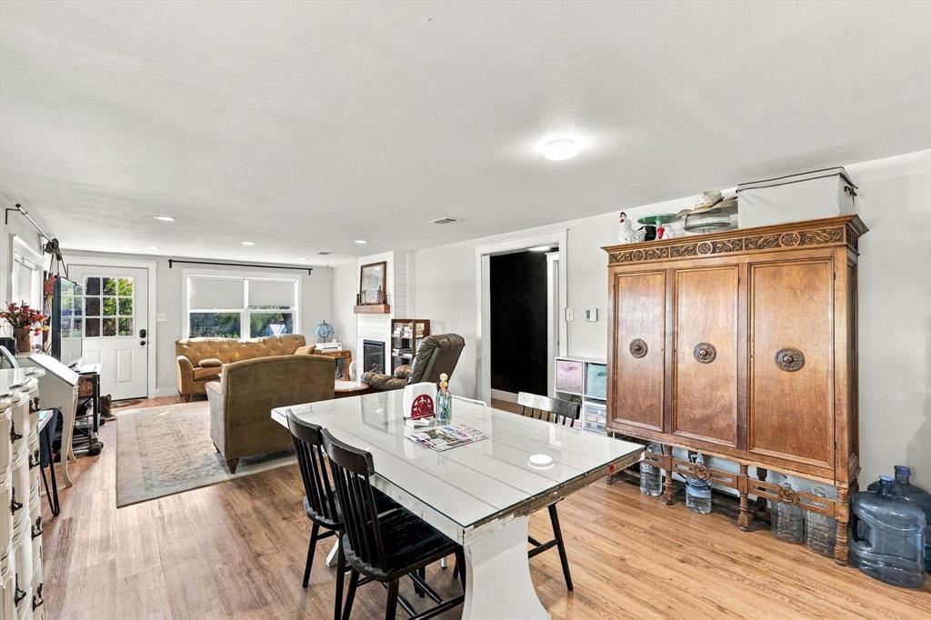 Open-concept interior featuring wood-finish flooring, recessed lighting, and a fireplace with a wood mantel