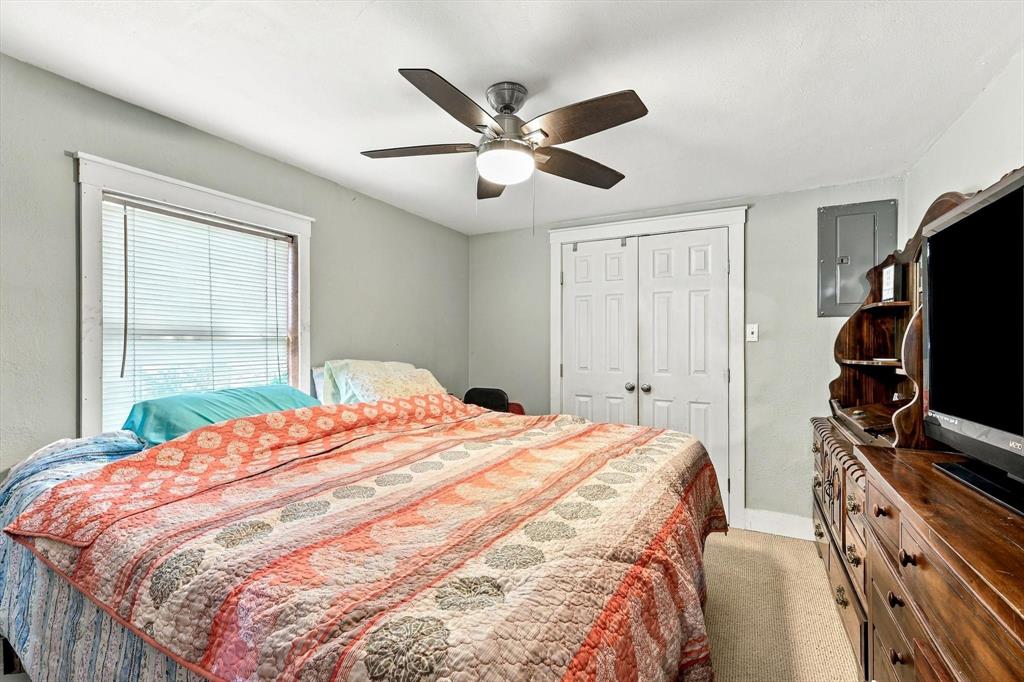 Room featuring carpeted flooring, a ceiling-mounted fan with integrated light, a multi-pane window with trim, and a double-door closet