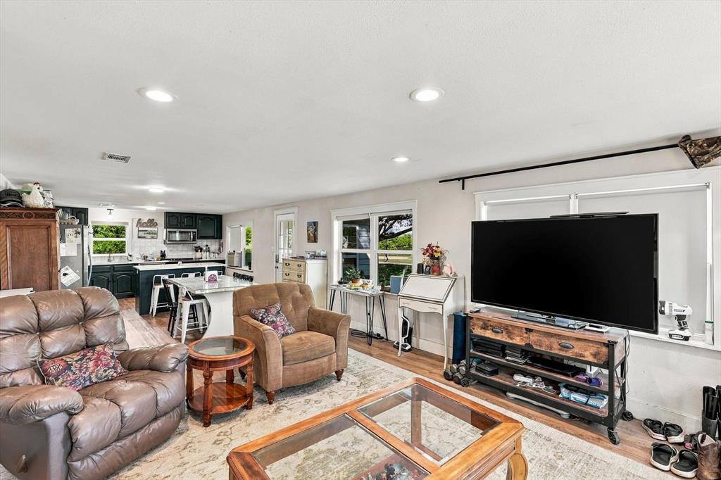 Open-concept interior featuring wood-finish flooring, recessed lighting, and a kitchen island with stone countertop