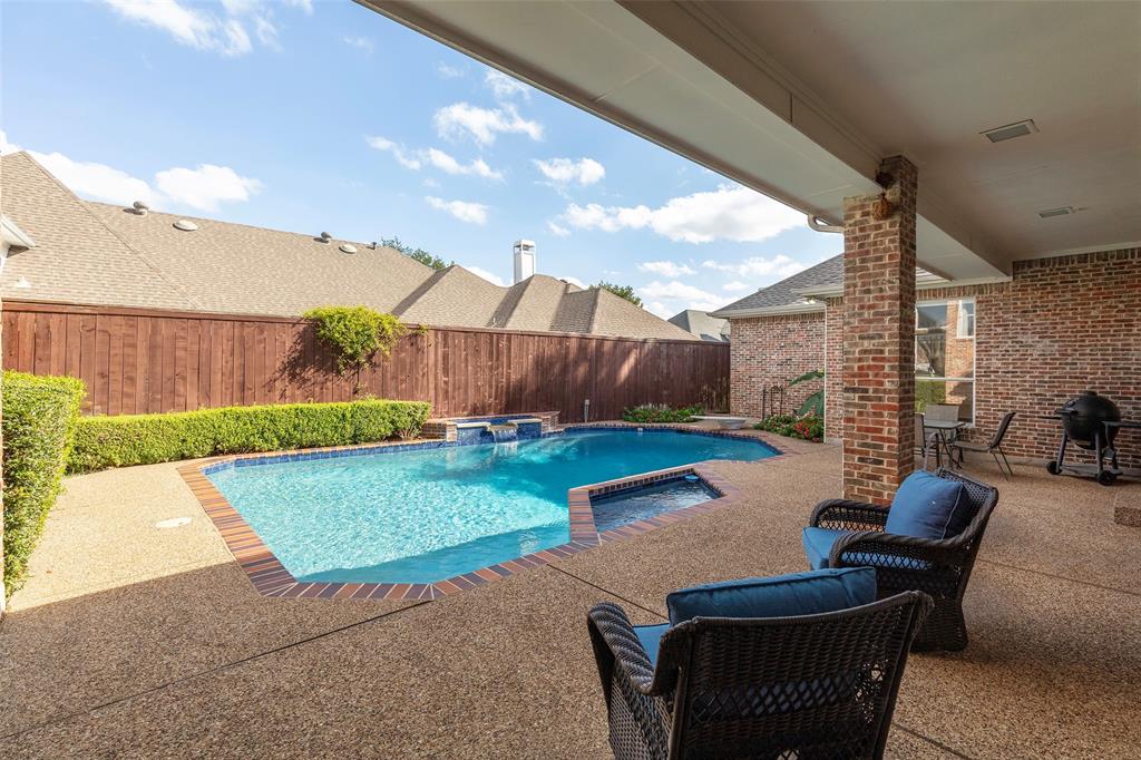 Step outside into your own private backyard oasis, where a spacious covered patio looks out over a sparkling custom pool designed for total relaxation.