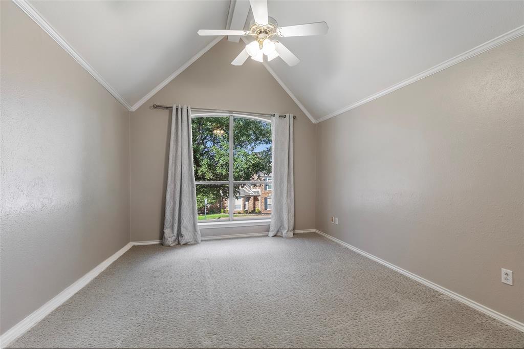 A vaulted ceiling and tall arched window give this upstairs bedroom character, with leafy views and space to make your own.