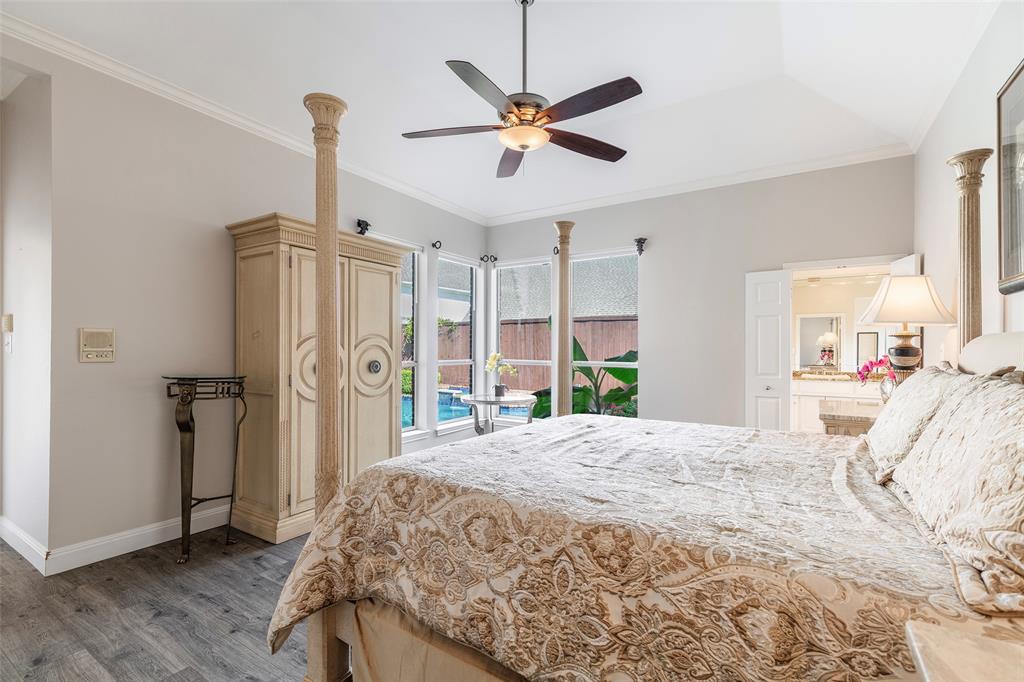 Wake up to views of the backyard pool through a wall of windows that fills the primary bedroom with natural light.
