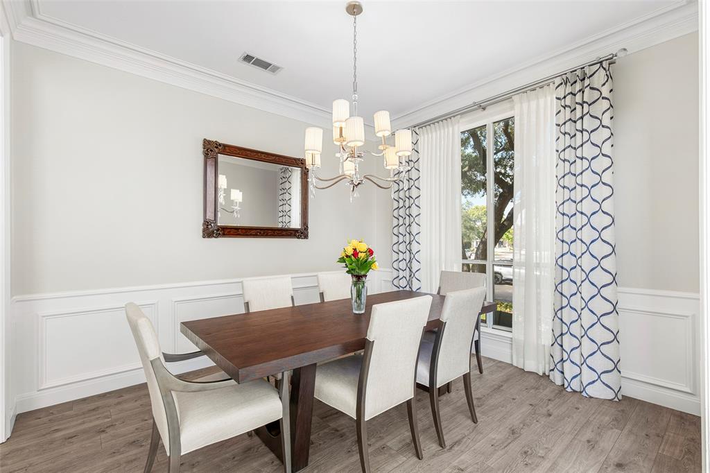 Elegant wainscoting and a classic chandelier elevate the separate dining room, offering a sophisticated and intimate setting tailored perfectly for holiday dinners and celebrations.
