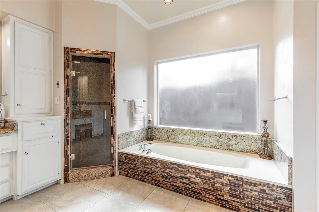 Unwind in the jetted tub beneath a large privacy window, or enjoy the separate glass-enclosed shower with a built-in bench.