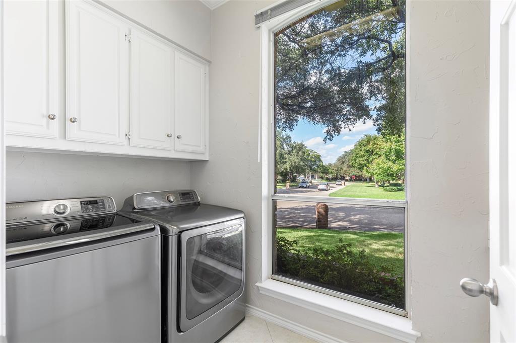 Located at the front of the home, the separate utility room offers natural light, overhead cabinetry, a sink and a shower that doubles as a convenient dog wash