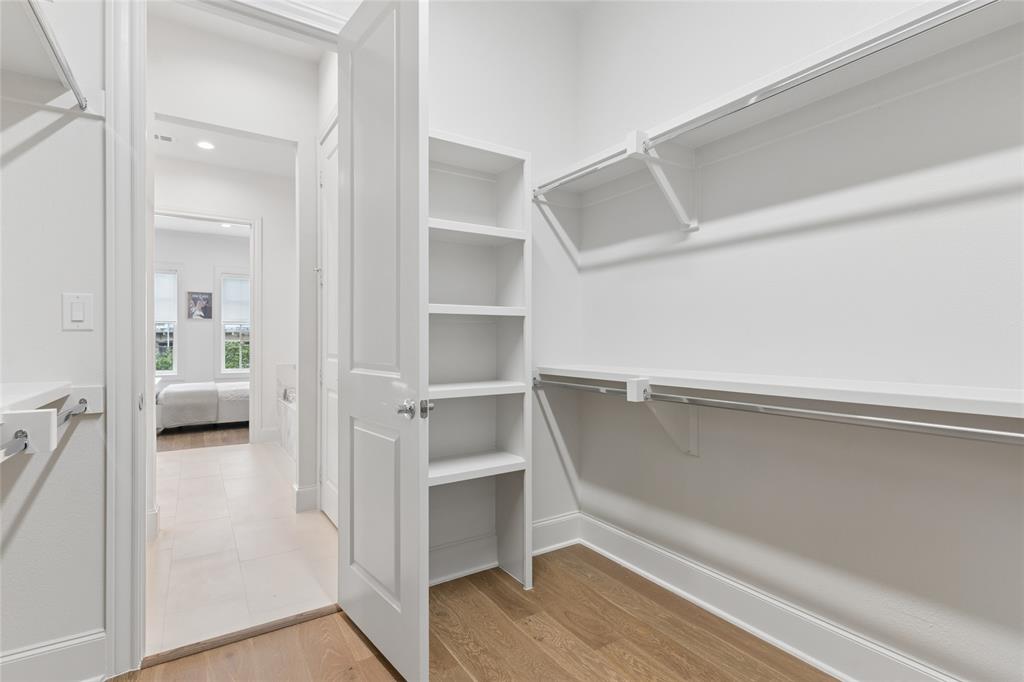 Primary bedroom offers a huge walk-in closet. Image of model home with similar layout.