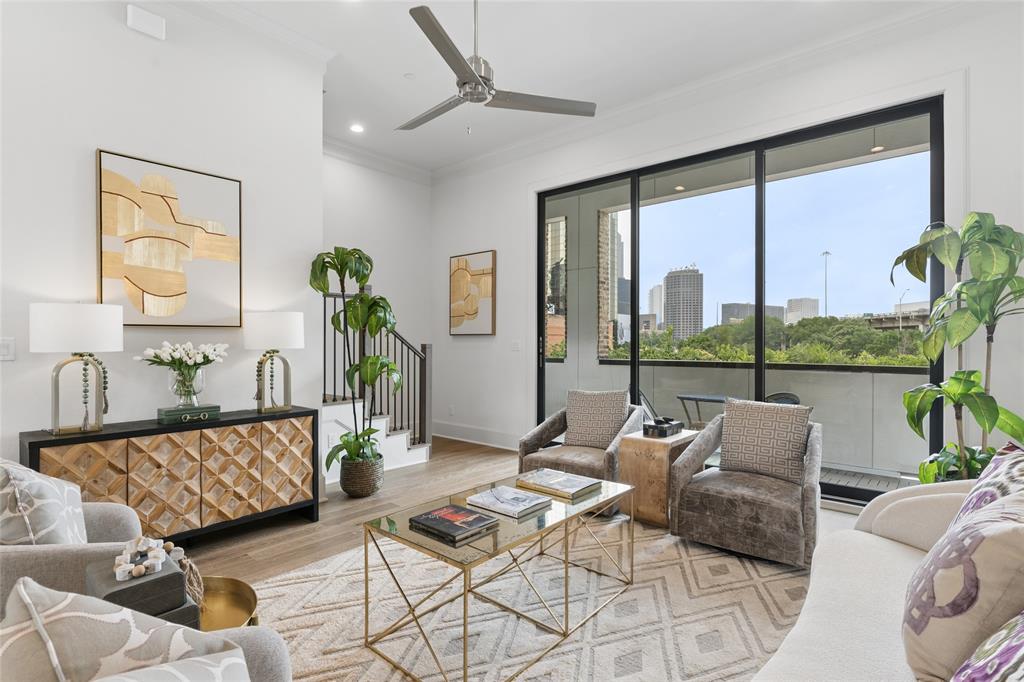 The main living level features an open layout with soaring 12-foot ceilings and 10-foot sliding glass doors that seamlessly connect the indoor and outdoor living spaces. Image of model home with similar layout.