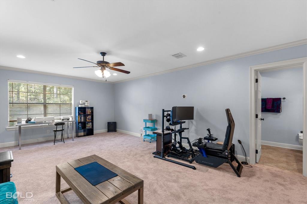 Spacious room featuring neutral carpeting, crown molding, recessed lighting, and a ceiling fan with integrated lighting