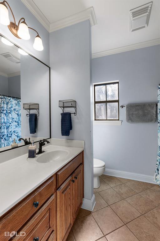 Bathroom vanity with wood-finish cabinetry, light-toned solid surface countertop, dark-finish faucet, wall-mounted light fixture, and tile flooring