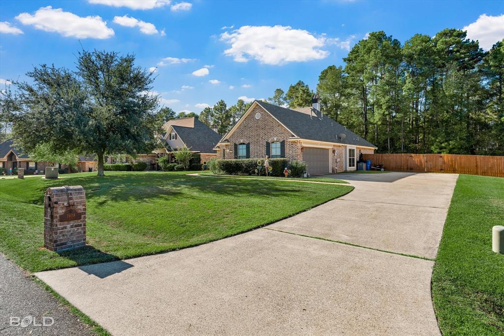Brick exterior residence featuring a gabled roof, attached garage, concrete driveway, and masonry mailbox