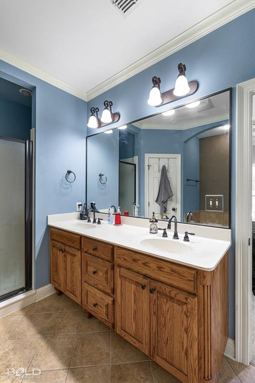 Double vanity featuring wood cabinetry, white countertops with dual integrated sinks, dark metal fixtures, and a large wall-mounted mirror