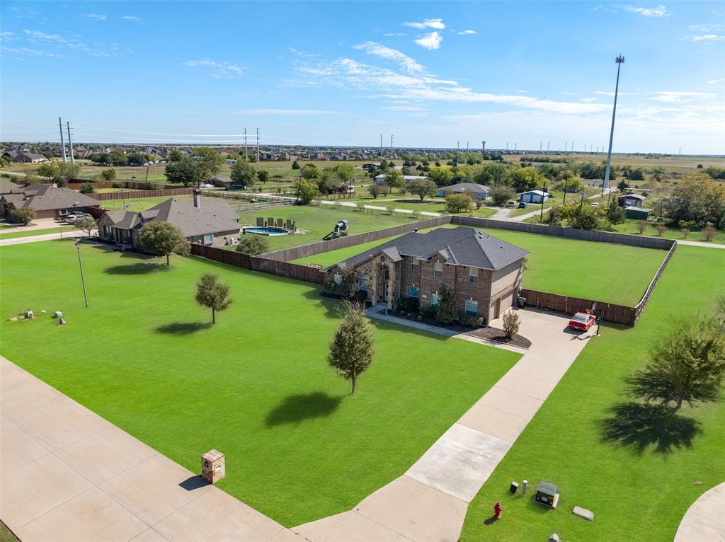 Brick exterior residence featuring a multi-hipped roof, an expansive fenced lot, and a concrete driveway