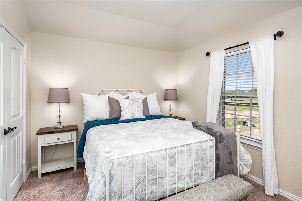 Neutral interior walls, wall-to-wall carpeting, and a single window with horizontal blinds and hardware