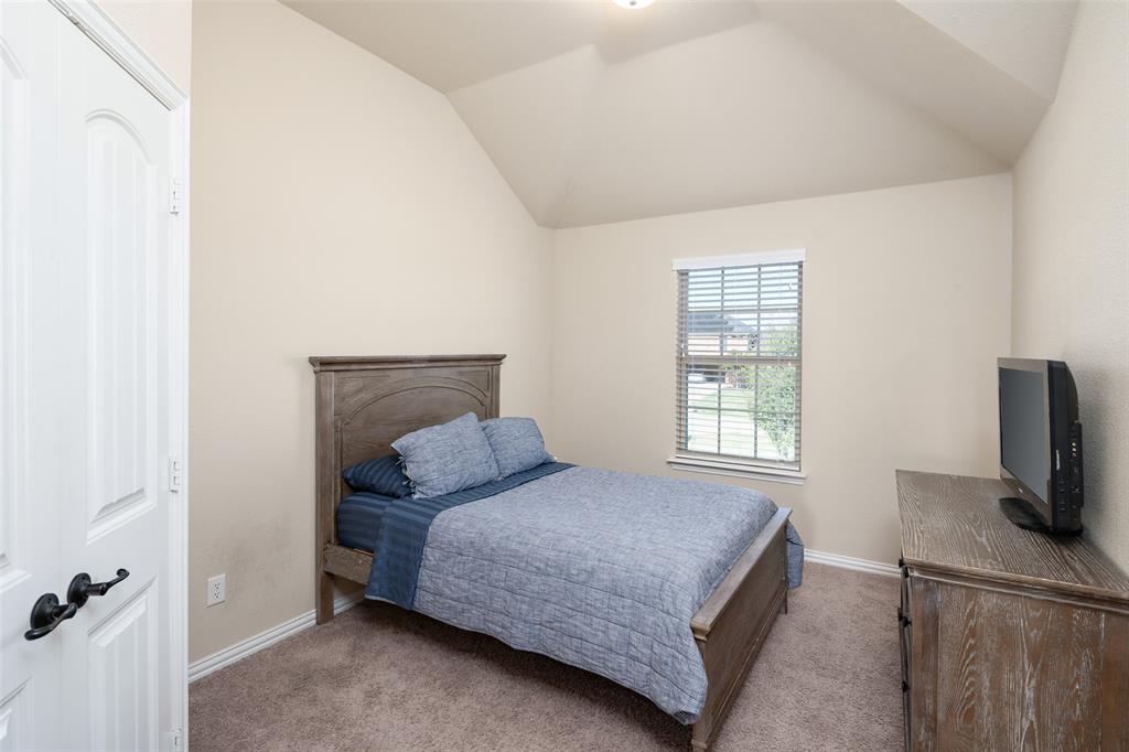 Vaulted ceiling, wall-to-wall carpeting, window with blinds, and paneled interior door with matte black hardware