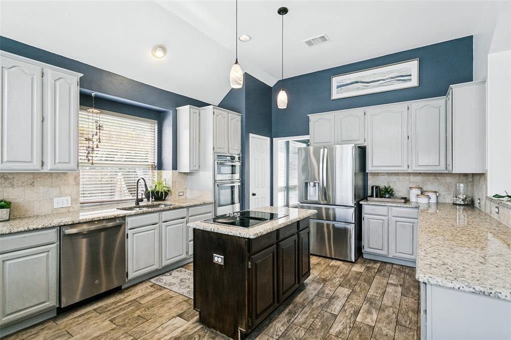 Find gray stained cabinetry, a double oven (one is a microwave + convection combination)