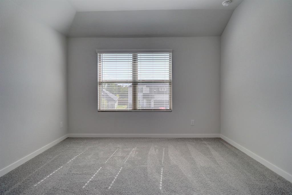 Recessed ceiling with an integrated light fixture, window with horizontal blinds, and gray patterned carpet