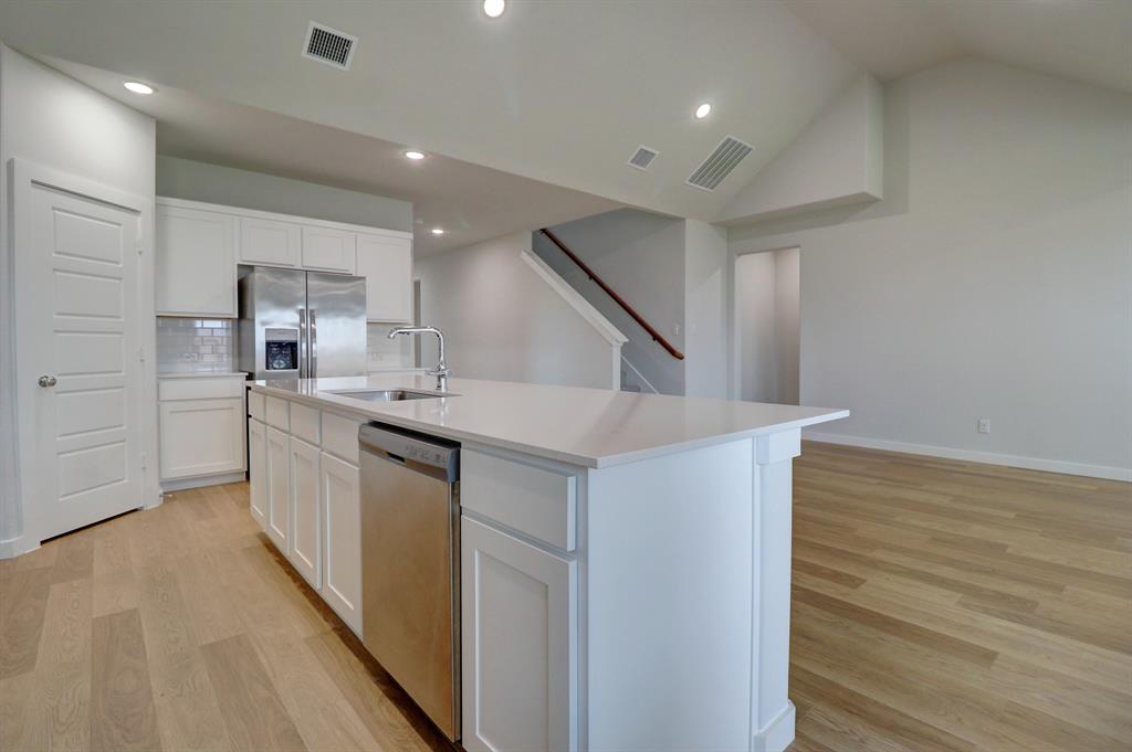 Kitchen island with an undermount sink and stainless steel appliances
