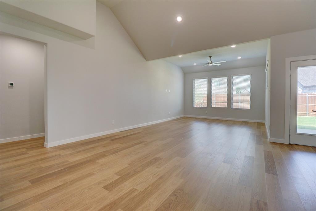 Vaulted ceiling, recessed lighting, wood-finish flooring, ceiling fan, and multiple windows