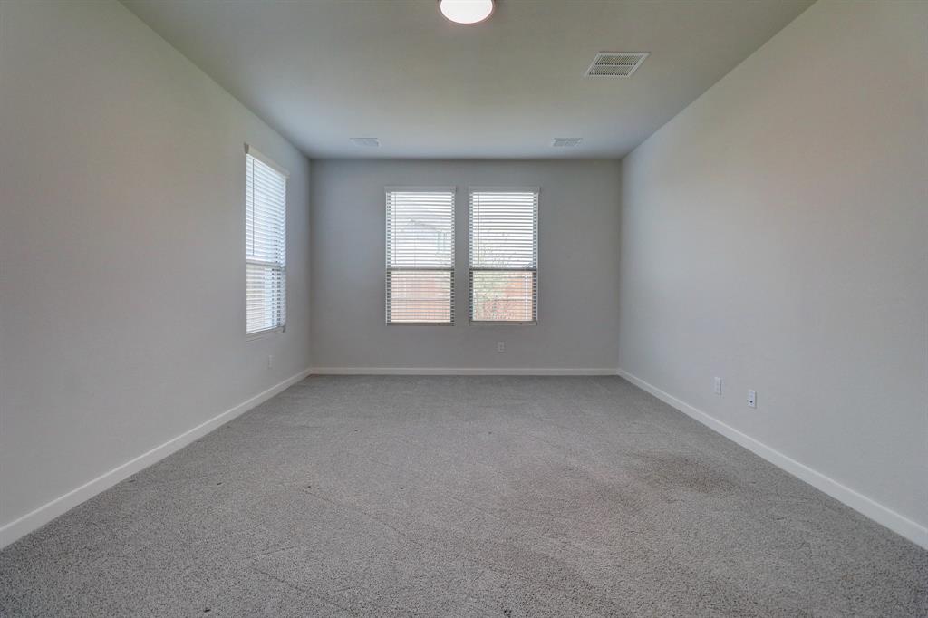 Neutral wall paint, plush carpet, recessed lighting, and multiple windows with blinds