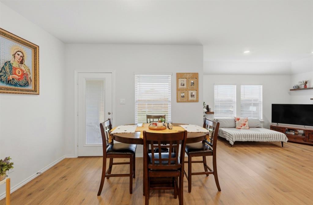 Open-concept room featuring wood-finish flooring, recessed lighting, white walls, and glass-paneled exterior door