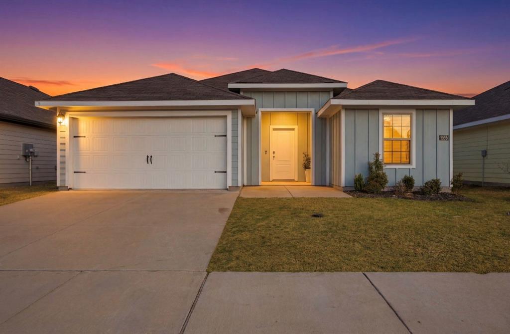 Single-story residence featuring a board-and-batten exterior, a two-car garage, a covered entryway, and a concrete driveway Single-story residence featuring a board-and-batten exterior, a two-car garage, a covered entryway, and a concrete driveway