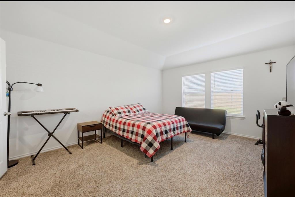 Neutral-toned wall-to-wall carpeting, tray ceilings, recessed lighting, and dual windows with horizontal blinds