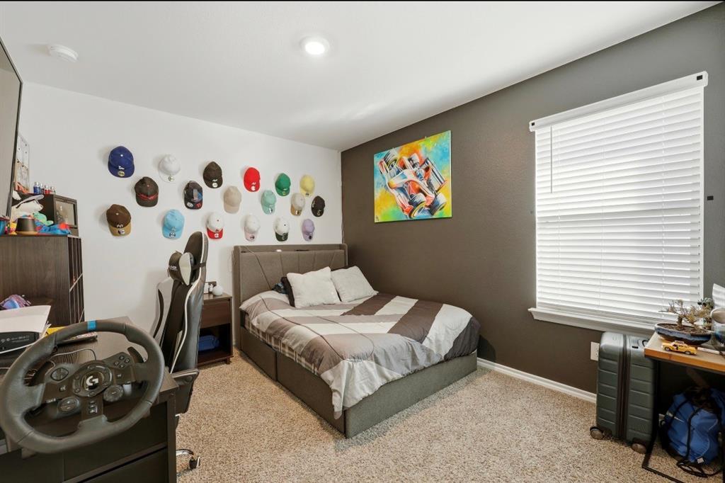 Bedroom featuring neutral carpeting, a dark charcoal accent wall, a single-hung window with fitted blinds, and recessed lighting
