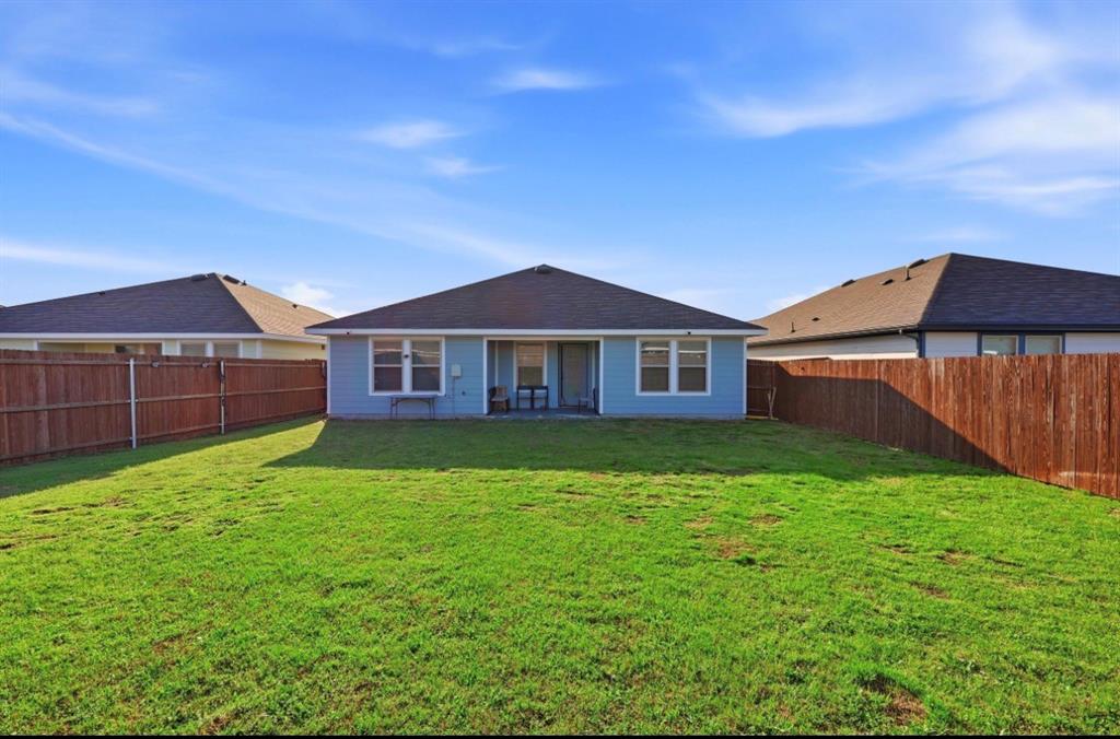 Expansive backyard featuring a large grass lawn and wood privacy fencing