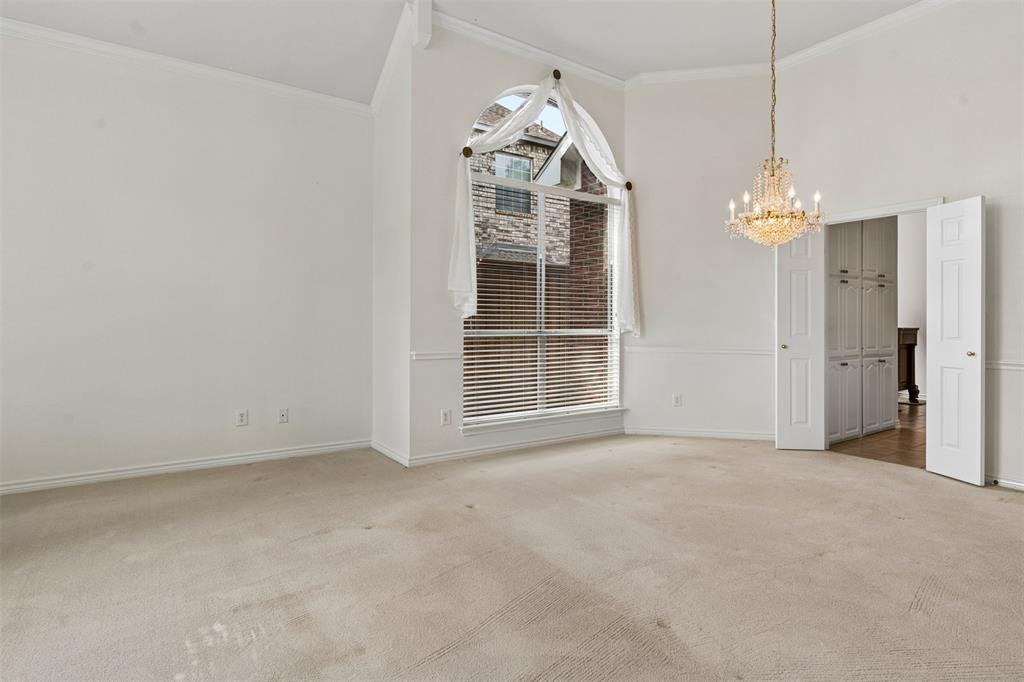 High ceilings, arched top window, crystal-style chandelier, and built-in cabinetry