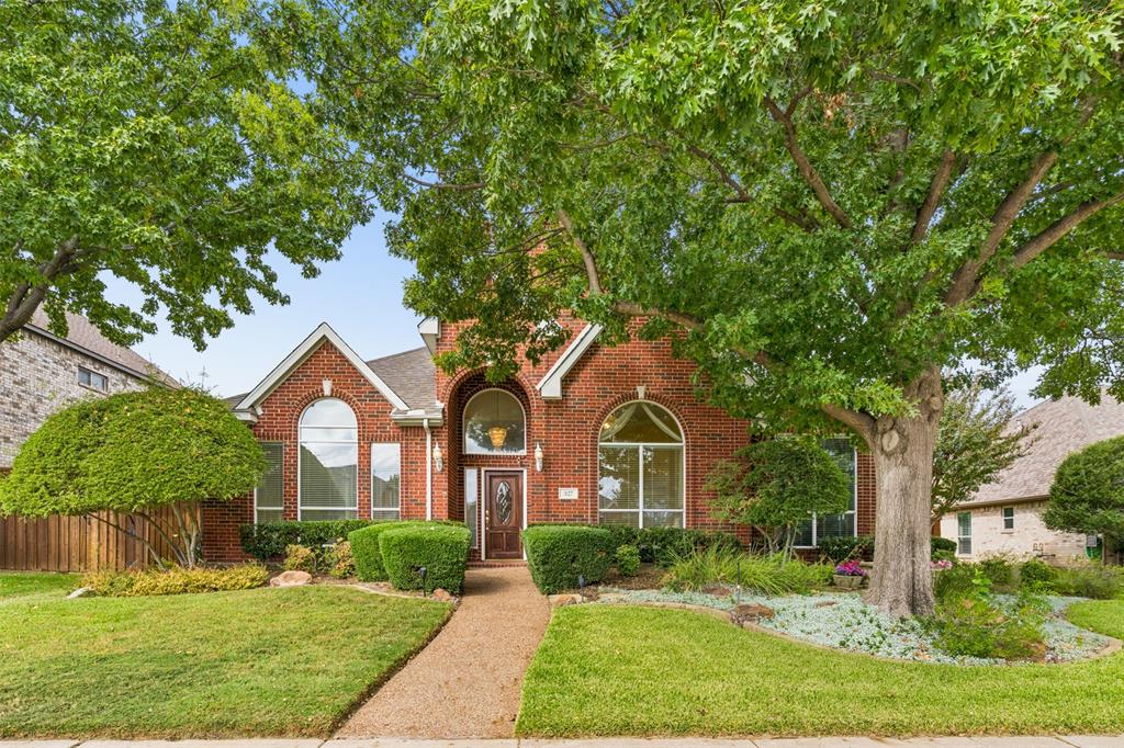 Red brick exterior featuring a steep-pitched roofline, an arched entryway with decorative glass door, and large multi-pane windows with arched transoms