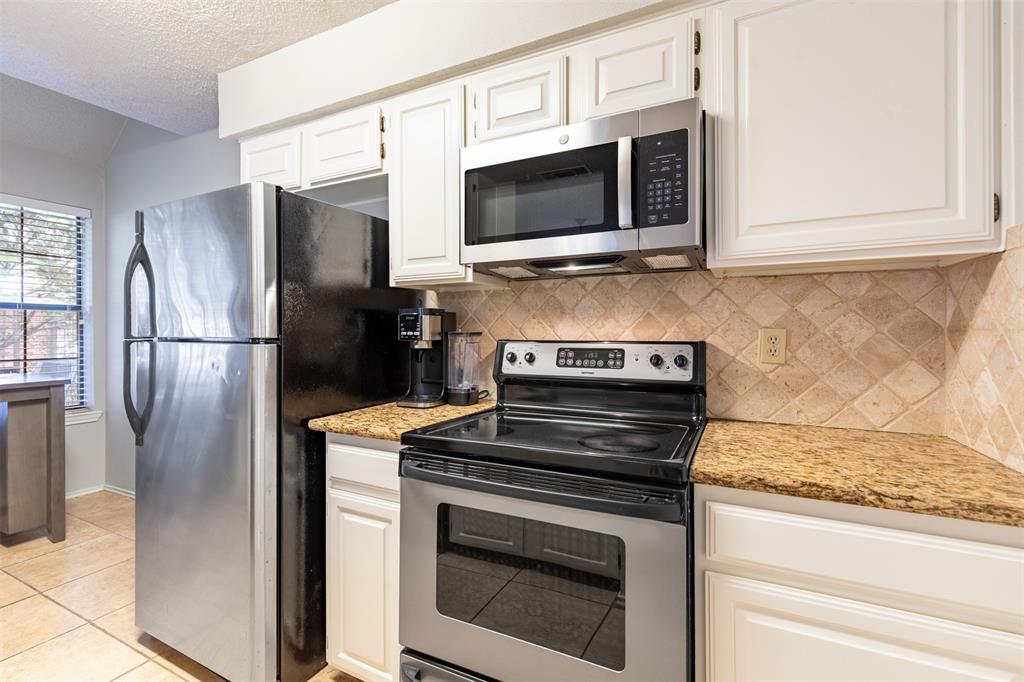 White kitchen with stainless appliances.