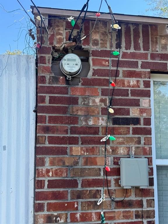 Close-up of the exterior brick wall and electric meter.