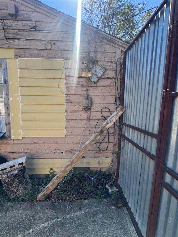 Side exterior view showing siding, utility connections, and gated access.