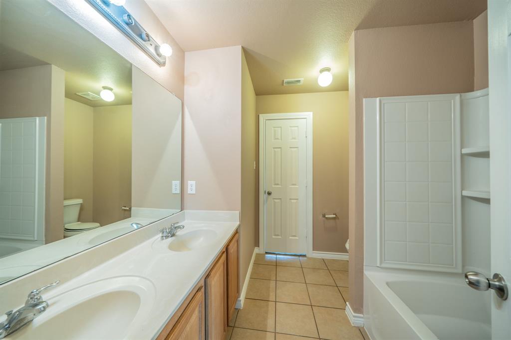 Upstairs jack and jill bathroom with dual sinks, built-in cabinets and granite countertop.
