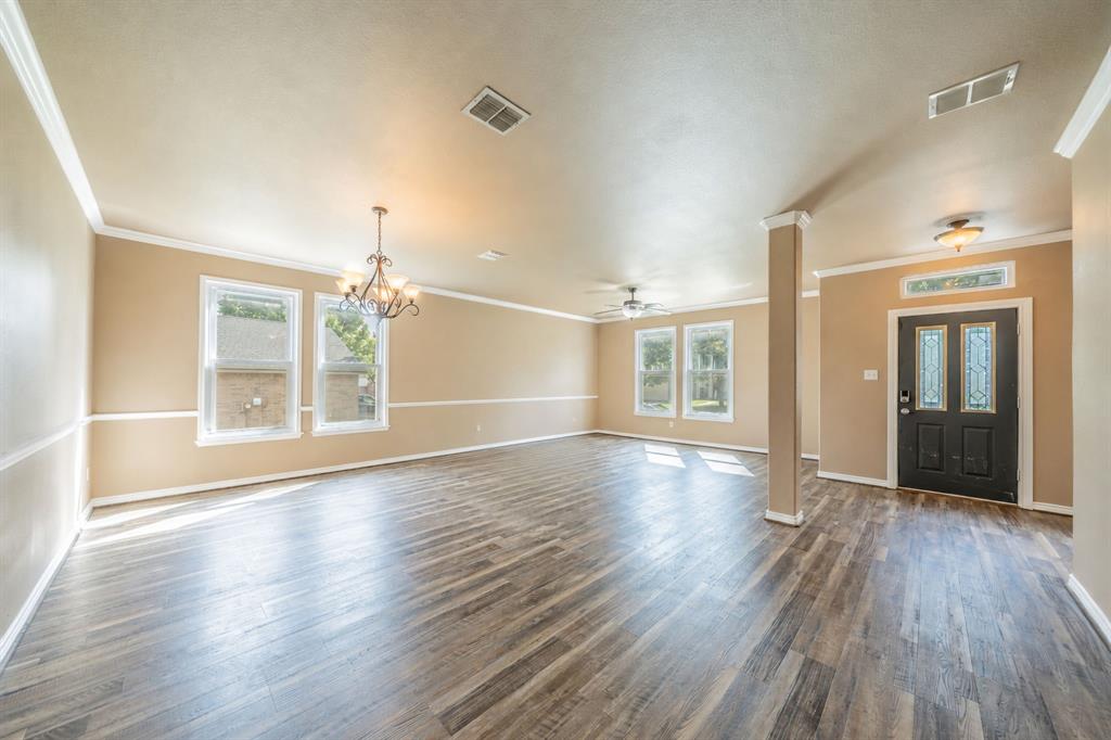 Formal dining room with decorative lighting and formal living area with ceiling fan, near the front door entry way.