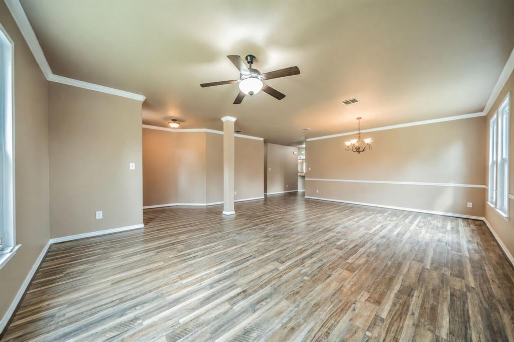 Front formal living room with ceiling fan looking toward formal dining room and entry hallway.