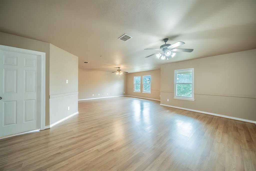 Large upstairs living area and game room with two ceiling fans.