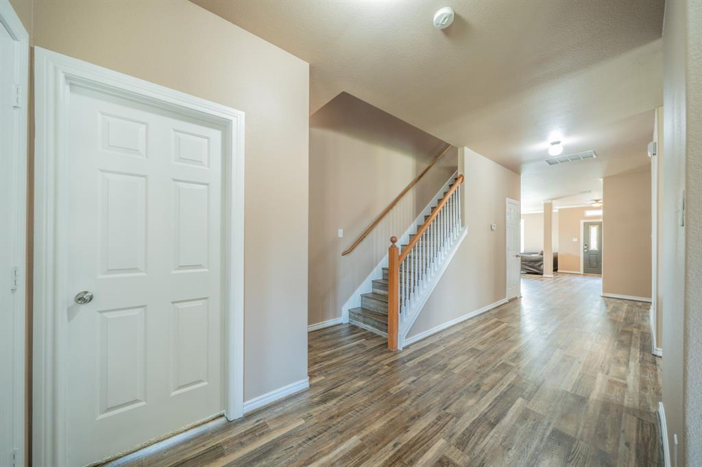 Entry hallway from kitchen area looking towards stairway and front door.
