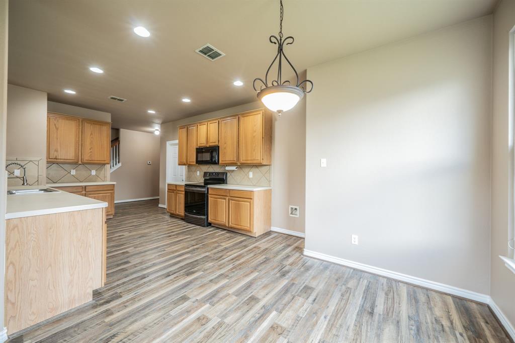 Breakfast nook with decorative lighting, looking into the kitchen with built-in microwave, range and water line for refrigerator. Breakfast nook with decorative lighting, looking into the kitchen with built-in microwave, range and water line for refrigerator.